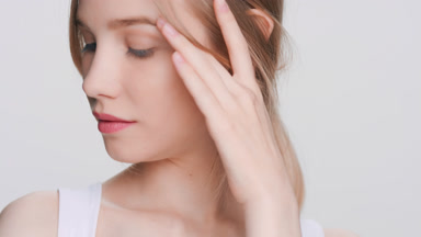 Young woman touches her face enjoying her perfect skin