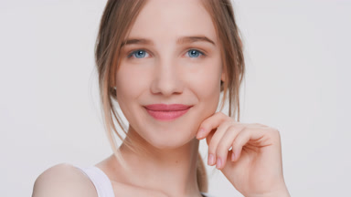 Beauty model touches her face and looks at camera