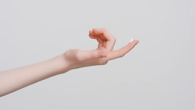 Hand with a drop of skin care cream on the finger
