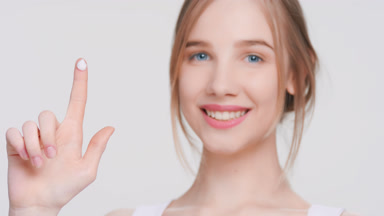 Young woman with a drop of a beauty cream on her finger