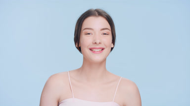 Young attractive brunette woman turns to the camera and smiles