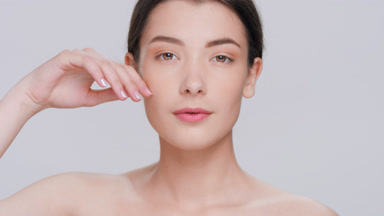 Young woman touches her face sliding hand along her cheek