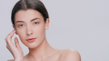 Young dark-haired woman posing for skin care products commercial