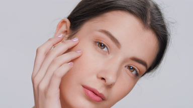 Young woman touches her face close-up beauty portrait