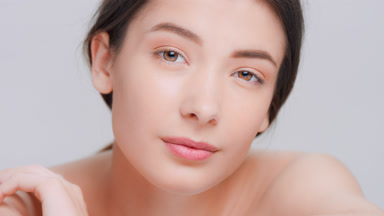 Dark-haired woman raises her head and looks at camera
