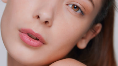 Brunette woman raises up her face and looks at camera close-up