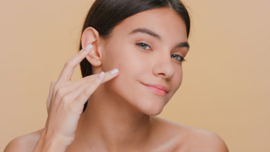 Beauty model runs her fingers from under eyes along the cheek