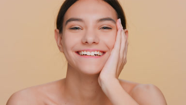 Young positive brunette beauty model looks at camera and laughs