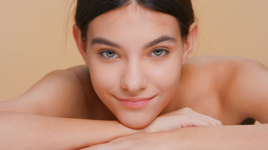 Young woman raises her head from her forearm and looks at camera