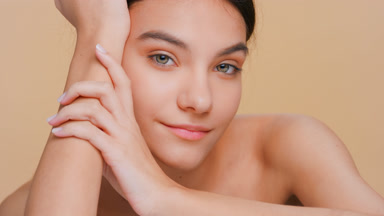 Woman touches her face running hand from chin up along a jawline