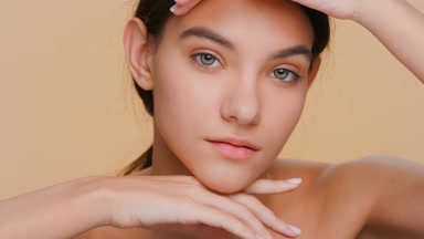 Woman touches face with both hands enjoying her perfect skin