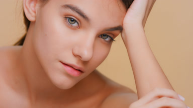 Beauty model touches her face running fingers along her cheek