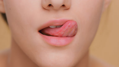 Detail shot of young woman licks her lips