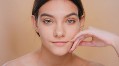 Young brunette woman gently touches her face | Beauty posing