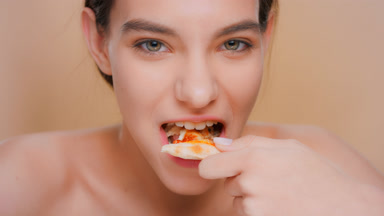 Young attractive brunette woman eating pizza