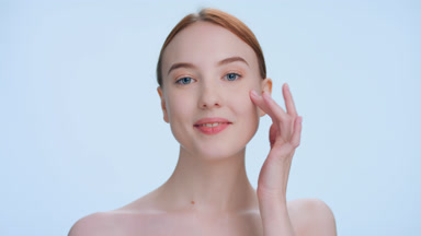 Young ginger woman touches her elastic skin two times