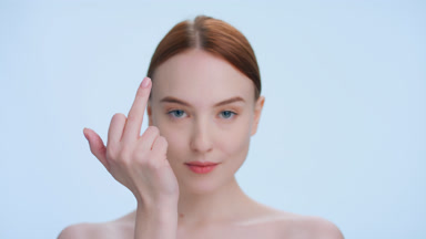 Young ginger woman makes a middle finger gesture