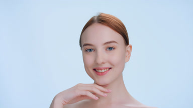 Young woman touches a chin with back side of her hand and smiles