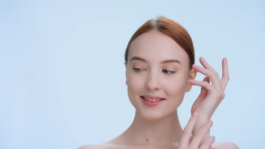Young woman touches her face demonstrating softness of her skin