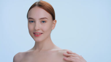 Ginger woman posing in front of the camera, skin care product ad