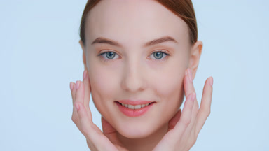 Woman touches her face from under eyes to temples down to cheeks