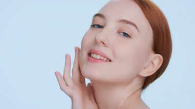 Beauty model touches her face sliding hand along a jawline
