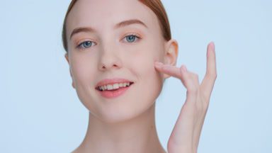 Ginger woman demonstrates elasticity of her face skin