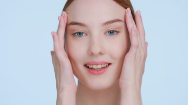 Young woman touches her face demonstrating skin elasticity