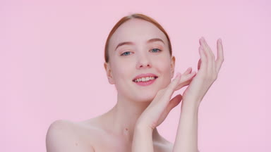 Attractive Ginger woman softly touches her hand and face skin