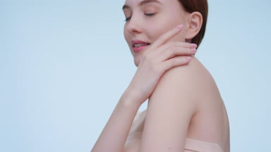 Low angle shot of ginger woman touches her perfect skin