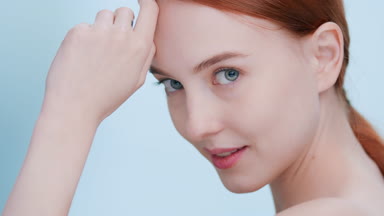 Close-up beauty portrait of young ginger woman looking at camera
