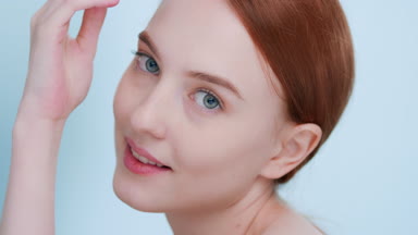 Beautiful ginger woman posing for skin care product commercial