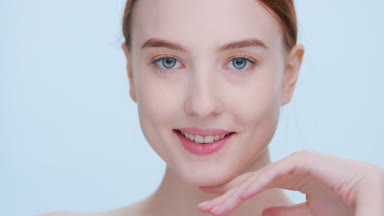 Young woman with pure skin dynamically turns and looks at camera