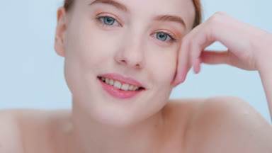 Young ginger woman poses for face cream commercial