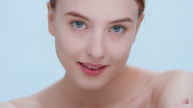 Young woman turns and looks at camera touching her shoulder