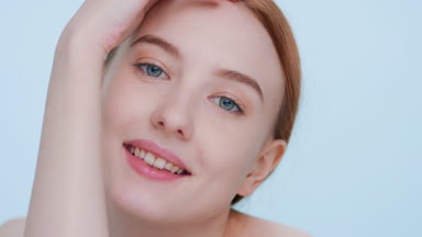 Young woman touches her skin sliding hand along a forearm