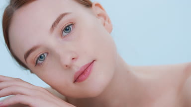 Young woman tilts her head and slowly lays cheek on her hand