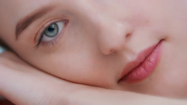 Detail of young woman laying on her hand open eye