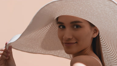 Young woman in a hat turns to the camera and blows a kiss
