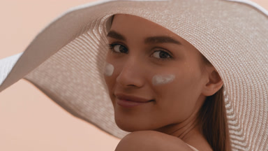 Woman with smears of sun cream on her cheeks turns to the camera