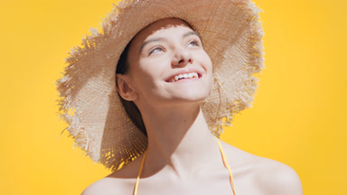 The sun comes out and young woman in a straw hat enjoys it