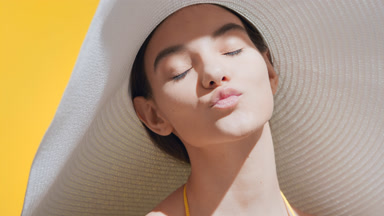 Young woman in a white hat turns to the camera and blows a kiss