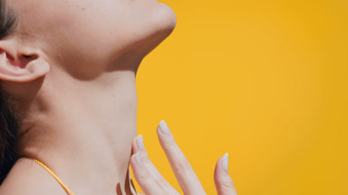 Woman in a swimsuit and a hat enjoys the sun touching her body