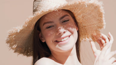 Young gorgeous Caucasian woman in a hat blows a kiss and smiles
