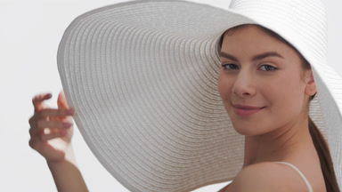 Woman in a white hat enjoys the sun, turns around and goes away