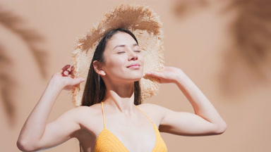 Young woman enjoys the sun and smiling at camera