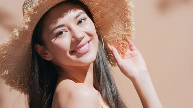 Girl in a straw hat turns around and smiles for the camera