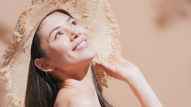 Young beauty model in straw hat turns around and enjoys the sun