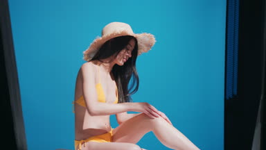 Young Asian woman applying sunscreen on her leg enjoys the sun