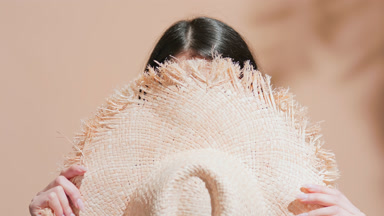 Positive Asian woman with two sun cream smears on her cheeks